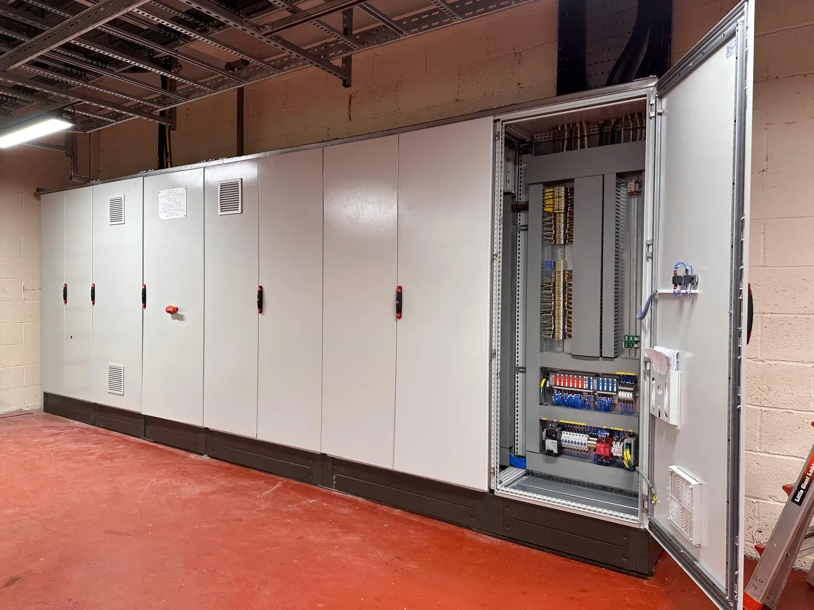 Motor control centre line-up with a cubicle door open during installation