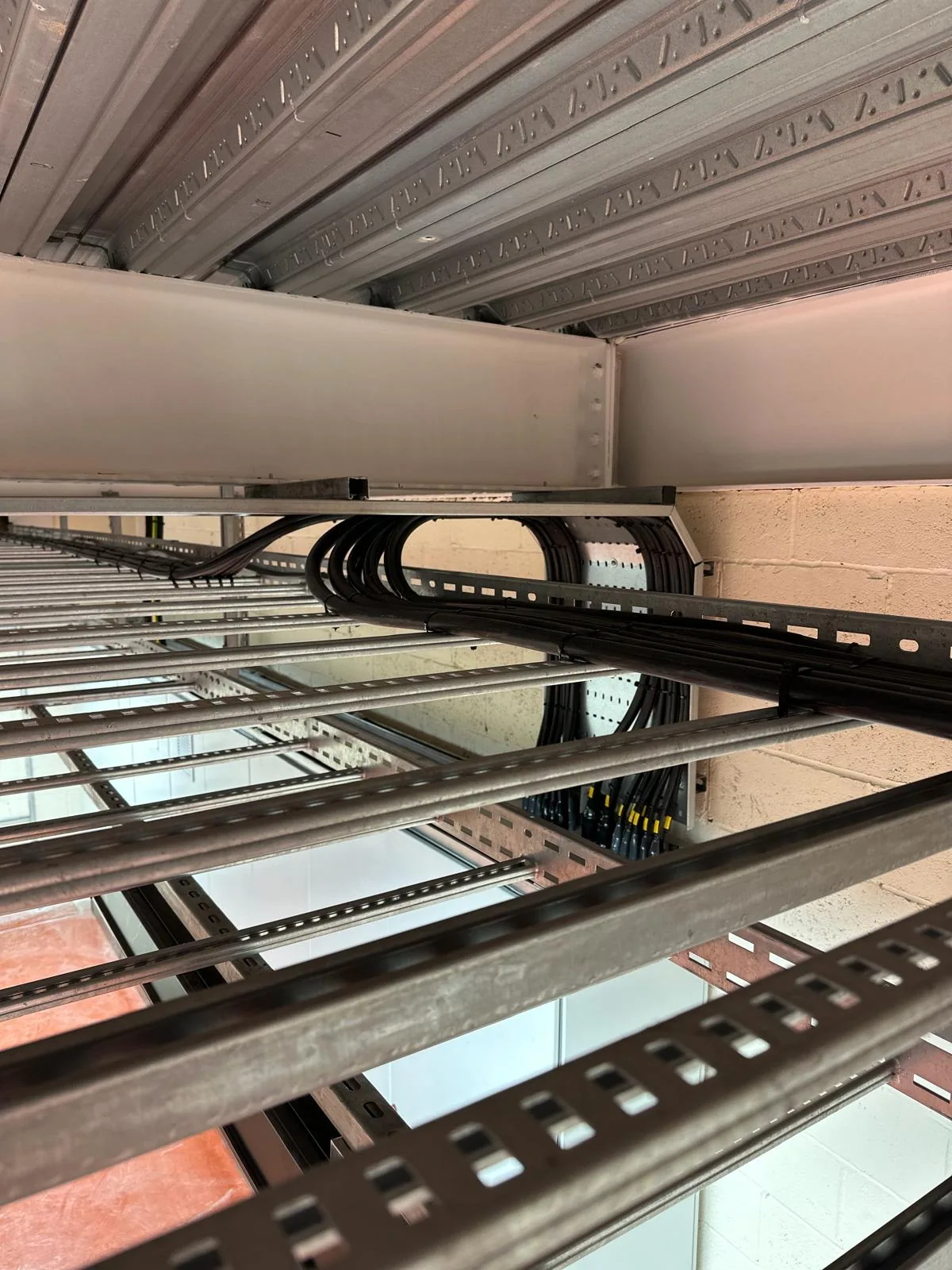 Stainless steel cable ladder and tray runs carrying segregated power and control cabling beneath the mezzanine