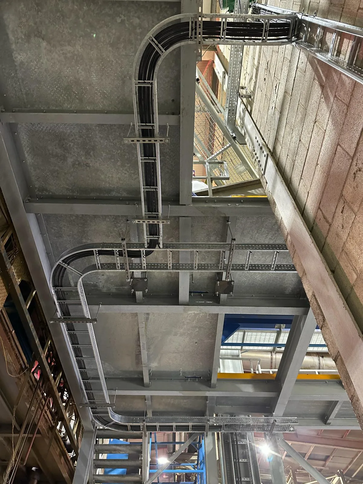 Stainless steel cable ladder carrying services vertically between the mezzanine and ground floor