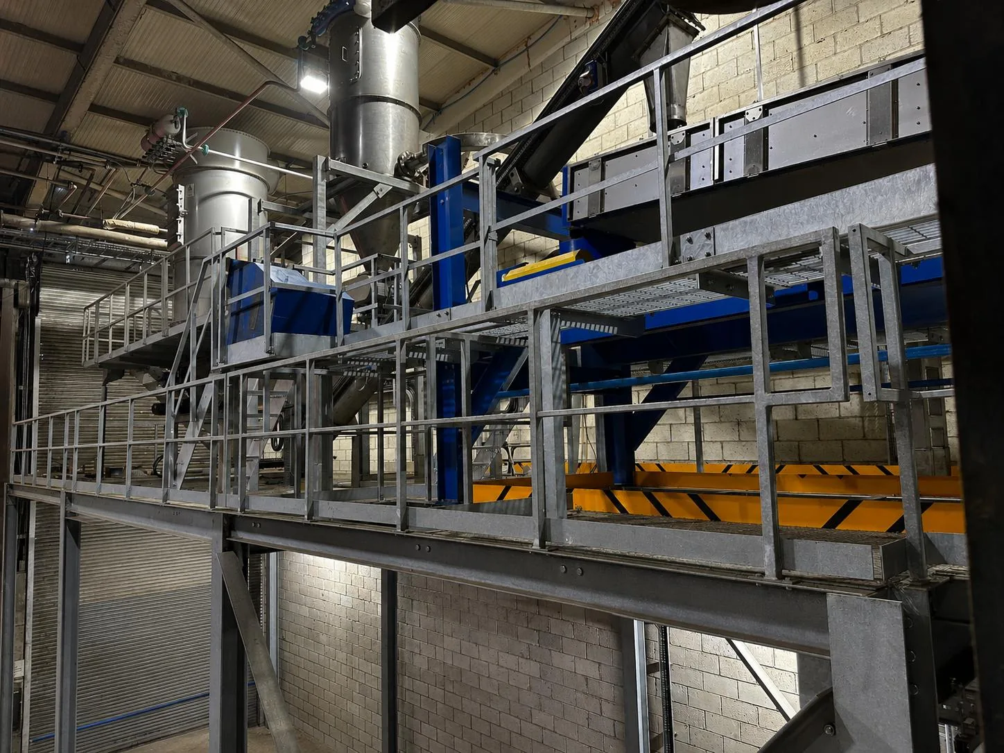 Mezzanine walkway alongside the grinding plant's cyclones and conveyor equipment