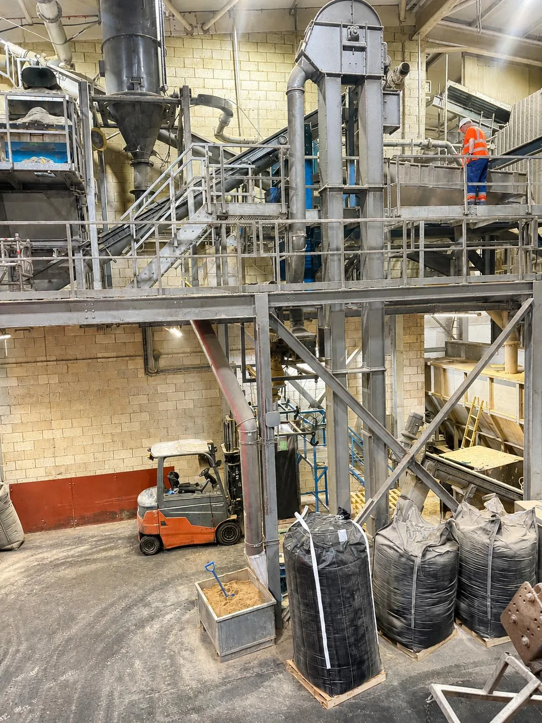 Grinding plant mill tower and cyclone assembly seen from the ground floor of the processing facility
